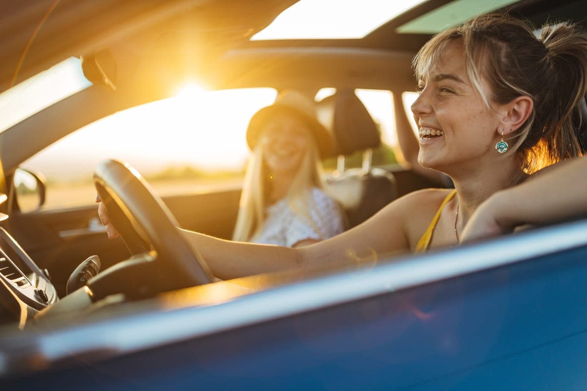 Two travellers driving at sunset